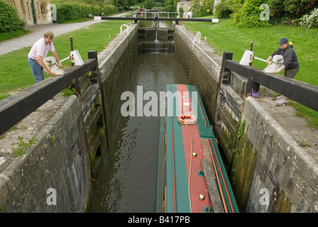 L'homme et de la femme de l'ouverture d'une porte d'écluse, 15-04, Kennet and Avon Canal, baignoire, Somerset, England, UK Banque D'Images