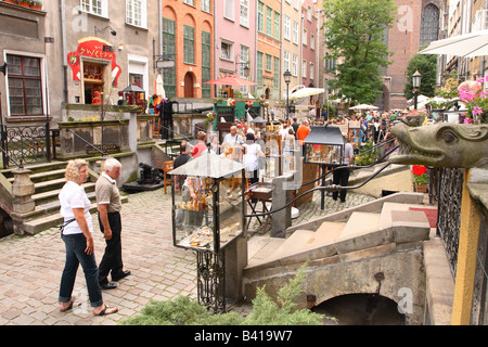 Gdansk Pologne visiteurs touristiques visites le long de Ulica Mariacka street à la recherche à l'affiche de l'ambre et argent Banque D'Images