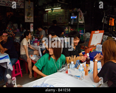 La jeune thaïlandaise de manger à l'un des marché de Chatuchak's café / restaurants Banque D'Images