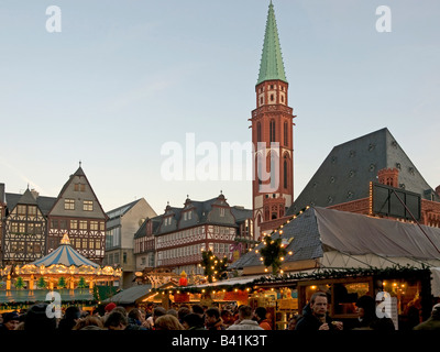 Foire de Noël sur la Place Römerberg Roemer Römer stands Stands de nourriture et de merry go round en face de l'ancienne église Nikolai Banque D'Images