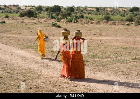 Les femmes sur leur façon de recueillir l'eau de l'étang de l'eau petits. Désert du Thar, Rajasthan, Inde. Banque D'Images