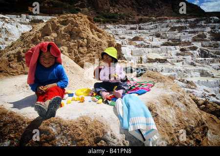 Les filles jouent à la Salineras de Mara, une ancienne mine de sel, près de Cuzco, Pérou. Banque D'Images