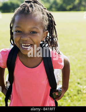 Young African American girl wearing backpack smiling at camera