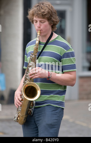 Jeune homme garçon adolescent de la rue dans la rue à jouer du saxophone Ludlow Shropshire en Angleterre Banque D'Images