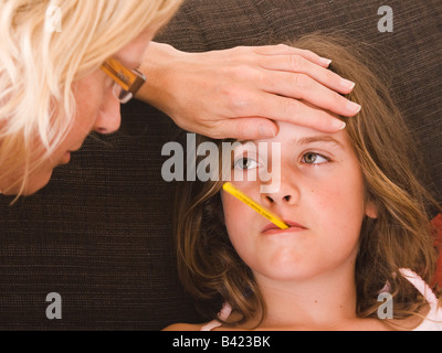 Mère et petite fille avec le thermomètre dans la bouche Banque D'Images