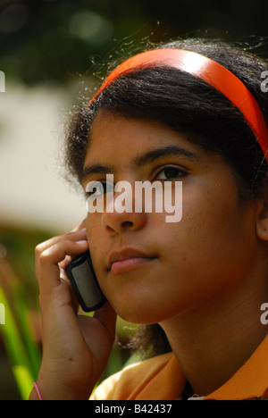 Une jeune latina adolescent parle d'un téléphone mobile. Ce genre de technologie est très populaire parmi les adolescents Banque D'Images