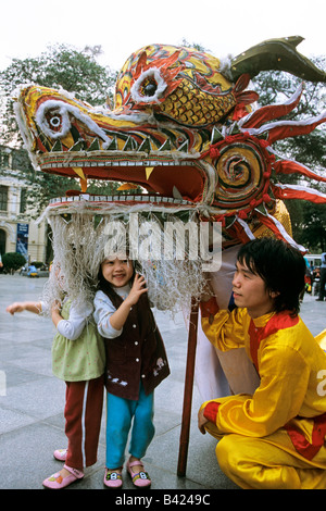 À Hanoi, Vietnam, petite fille intrépide de pics de sous tête de dragon pendant les célébrations du Nouvel An lunaire du Têt. Banque D'Images