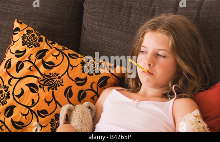 Petite fille avec le thermomètre dans la bouche Banque D'Images