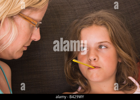 Mère et petite fille avec le thermomètre dans la bouche Banque D'Images