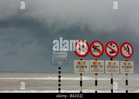 Plage signes écrits en anglais et en chinois à Taïwan que les approches. Banque D'Images