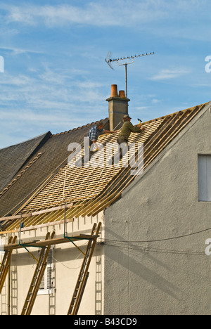 Les constructeurs travaillent sur toit de maison, en France. Banque D'Images