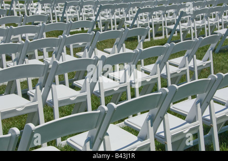 Des rangées de chaises pliantes blanc sur la pelouse avant l'arrivée d'invités Banque D'Images