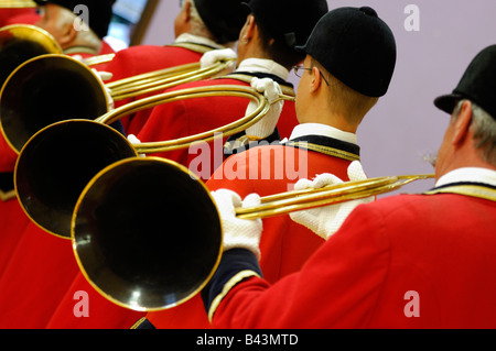 Groupe de musiciens qui jouent sur cor de chasse et avec robe rouge traditionnelle - France Banque D'Images