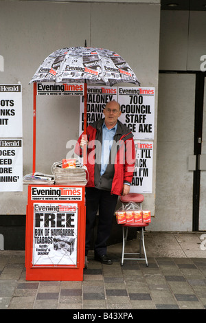 UK Scotland Glasgow Sauchiehall Street vendeurs de journaux sous blocage parapluie de papier journal Banque D'Images