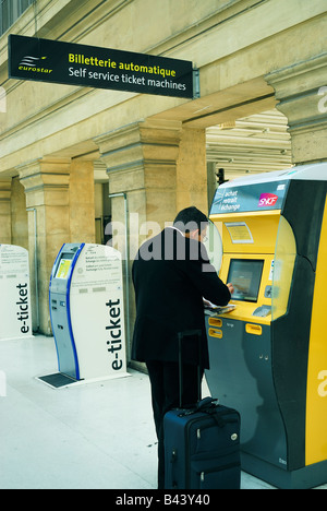 Paris France, Gare du Nord, Man from Behind, Acheter un billet de train au distributeur automatique à l'intérieur, écrans de gare, billet sncf Banque D'Images