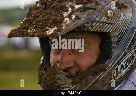 Homme avec un casque couvert de boue impliqués dans le circuit de motocross, près de Darvel Ayrshire en Écosse Banque D'Images