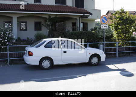 Voiture garée en face de no parking sign en zone-remorquage Banque D'Images