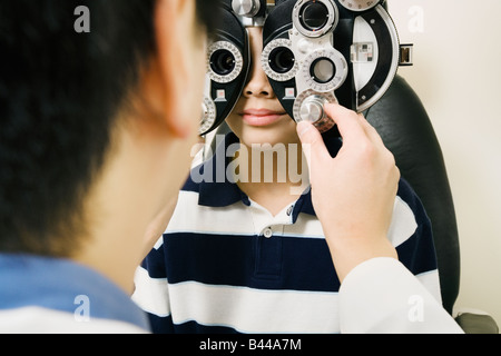 Asian male optometrist examining patient Banque D'Images