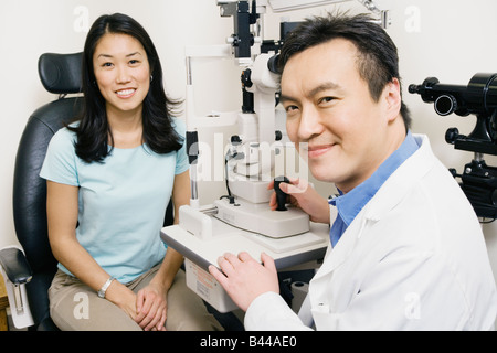 Asian male optometrist examining patient Banque D'Images