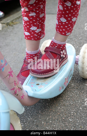 Girl wearing red shoes sur son triporteur Banque D'Images