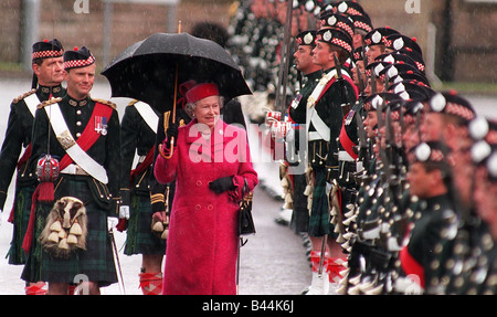 Son Altesse Royale la Reine Elizabeth II inspecte la garde à la présentation des couleurs de soldats écossais holding glasses en pluie humide Banque D'Images