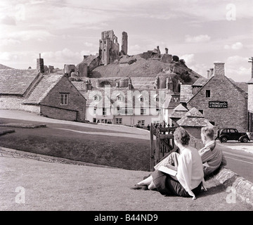 Corfe Castle Dorset s'élève derrière stone cottages Corfe Castle s emplacement situé sur une colline dans un fossé entre deux autres hills Banque D'Images