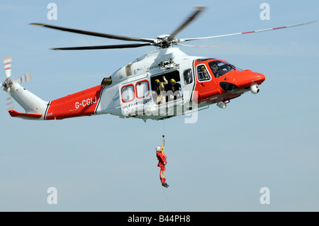 Garde côtière canadienne d'hélicoptères de recherche et de sauvetage à l'exercice d'un treuillage d'équipage RNLI Banque D'Images