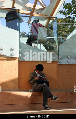 Man reading book dans la Serpentine Gallery Pavilion 2008 par Frank Gehry Banque D'Images