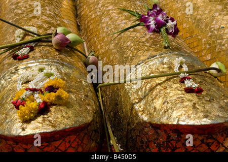 Une vue rapprochée des offrandes de feuilles et de fleurs d'or sur les pieds de la statue de 32 mètres de haut du Bouddha à Wat Indraviharn à Bangkok Thaïlande Banque D'Images