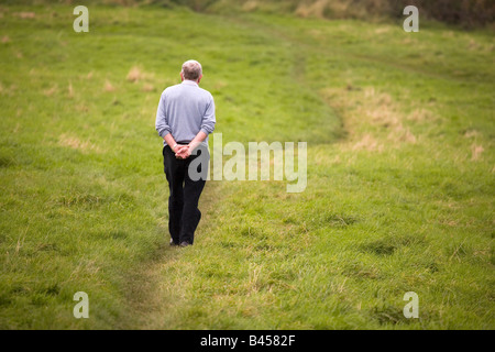 Seul un homme marche le long d'un sentier à travers un champ à Sunderland, en Angleterre. Banque D'Images