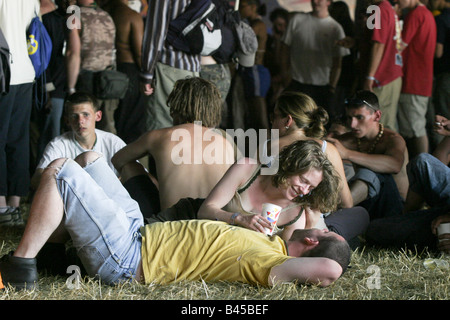 Festival de musique de Glastonbury 2003 ; Un couple partage un moment de détente allongé sur l'herbe dans la tente de danse Banque D'Images