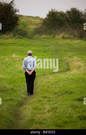 Seul un homme marche le long d'un sentier à travers un champ à Sunderland, en Angleterre. Banque D'Images