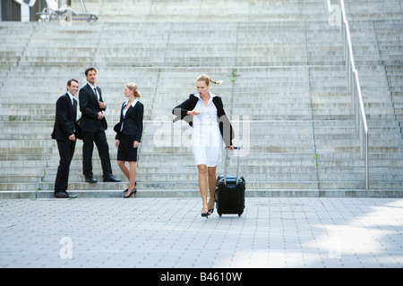 Allemagne, Baden-Württemberg, Stuttgart, Businesswoman walking avec cas d'affaires, en arrière-plan Banque D'Images
