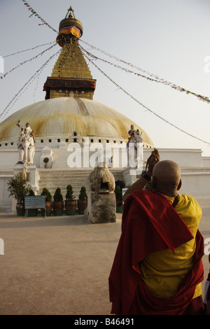 Le moine bouddhiste priant devant le grand stupa de Boudha Népal Banque D'Images