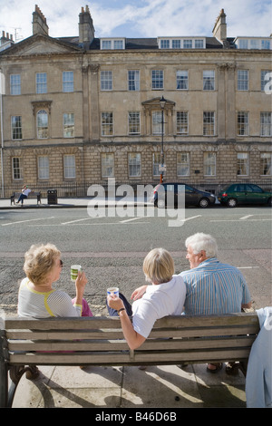 Les personnes ayant un plateau pique-nique sur banc dans Street Bath UK Banque D'Images