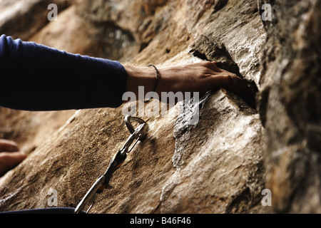 Rock Climber's hand holding sur une lacune dans le mur de la falaise Banque D'Images