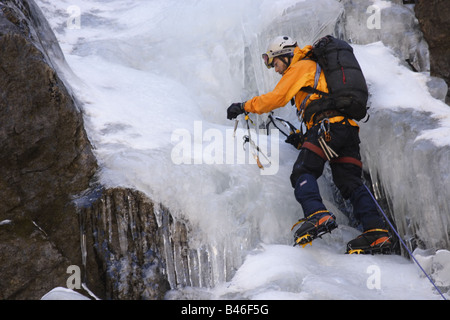 Grimpeur sur glace fixant une broche à glace sur un emplacement dans le langtang Himalaya, Népal Banque D'Images