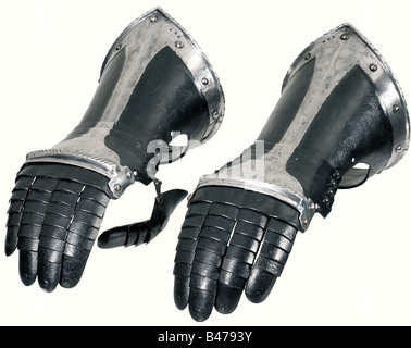 Une paire de gauntlets noir et blanc, allemand, vers 1570. Salopettes avec doigts en haut de l'échelle se chevauchant les plaques de doigt. Protège-porte avec une épaisse lingette à cordon. La protection des dos des mains qui glissent sur quatre lames. Plaques de pouce à charnière. Les bords des poignets sont câblés et réglés sous et s'élèvent jusqu'à un point. Ancien marquage armory avec trois points estampillés sur chacun. Pièces en cuir et en superposition remplacées. Longueur de chacun 34 cm. Historique, historique, XVIe siècle, armes défensives, armes, armes, armes, bras, dispositif de combat, objet, objets, photos, cl, Banque D'Images