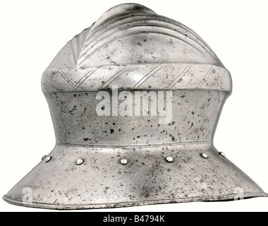 Un chapeau de guerre en fer, Augsbourg, milieu du XVe siècle. Bol en aluminium forgé d'une seule pièce avec arête centrale vive et à cinq plis. Il y a un trou de garniture en haut et deux de chaque côté. Un renflement environnant avec une décoration à encoches sur des côtés légèrement coniques. Bord large et incliné avec bord tourné, entouré de rivets de garniture. Il y a une bande décorative étroite avec gravure le long de la base du bord. La marque de la Ville d'Augsbourg est estampillée une fois sur le bord du bord. Hauteur 25,5 cm. Type de casque rare pour un homme aux bras, qui est confirmé par nume, Banque D'Images