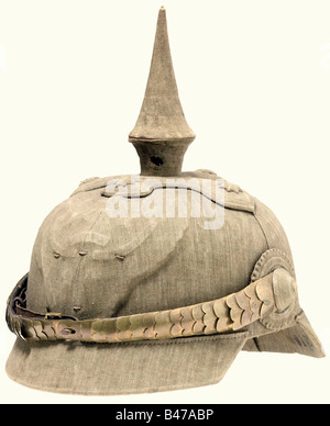 Un casque de manœuvre, pour le Dragoon Regiment König Carl I von Rumänien (1ère Hanoverian) No. 9 Metz UN casque de manoeuvres dans une version en liège recouvert d'un tissu gris de champ. La pointe amovible comporte deux orifices de ventilation. Toutes les fixations telles que la base transversale, les vis à tête bombée, la plaque avant et la coque ont été coupées et formées de bois et recouvertes de tissu. Écailles de chinelles métalliques légèrement grevées et dorées sur des broches de rosette recouvertes de tissu. Bandeau de sueur en cuir marron clair « ELOVIT ». Maker Ludwig Bordtfeld, Brême. Doublure beige en soie artificielle. Taille du timbre '7'. Estampillé '01E(?)' à l'arrière b, Banque D'Images