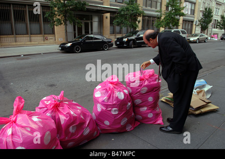 Colorful pink polka dot sacs poubelle en plastique sont empilés dans la rue en attente de collecte dans le Meatpacking District à New York Banque D'Images