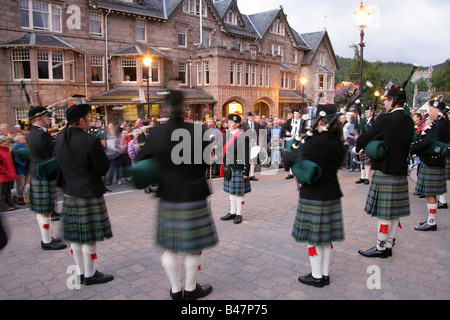 Village de Braemar, l'Écosse. L'Ballatar Pipe Band jouant dans Braemar village, avec la Fife Arms Hotel de l'arrière-plan. Banque D'Images