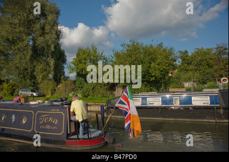 Un homme sur son bateau voyageant le long du Grand Union Canal dans l'ouest de Londres. Banque D'Images