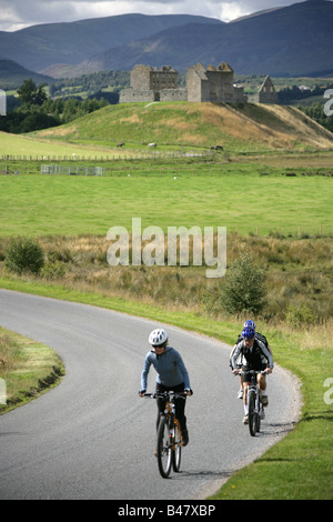 Le village de Kingussie, Scotland. Cyclistes sur la B970 en direction du nord avec la caserne Ruthven en arrière-plan. Banque D'Images