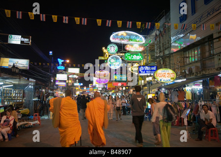 Deux moines bouddhistes parmi la foule d'étrangers et des enseignes au néon le long de Khao San Road à Bangkok en Thaïlande Banque D'Images