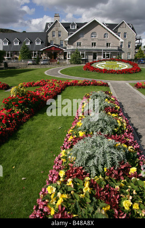 Le village de Kingussie, Scotland. Kingussie public gardens en fleurs avec le duc de Gordon Hotel en arrière-plan. Banque D'Images