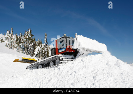Snow cat labourant la neige pour construire un snowboard jump Banque D'Images