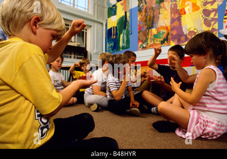 Une classe d'enfants jouer avec les aimants au cours d'une classe de sciences dans une école primaire Banque D'Images