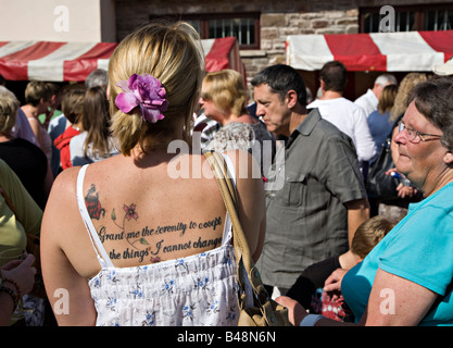 Femme en foule avec tatouage sur retour lecture Donne-moi la sérénité pour accepter les choses que je ne peux pas changer le pays de Galles UK Banque D'Images