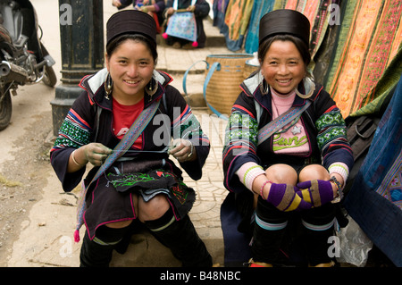 Deux femmes souriantes et heureuses de Hmong qui font des vêtements ethniques dans les rues de Sapa Vietnam Banque D'Images